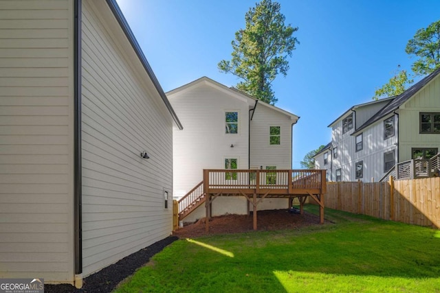 rear view of house with a yard and a wooden deck