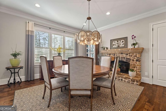 dining area with dark hardwood / wood-style flooring, a stone fireplace, and ornamental molding