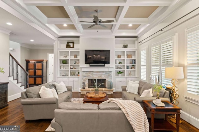 living room featuring a fireplace, coffered ceiling, built in shelves, ceiling fan, and beamed ceiling