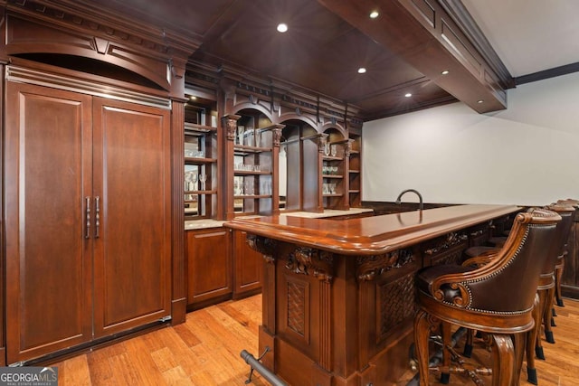 bar with light wood-type flooring and ornamental molding