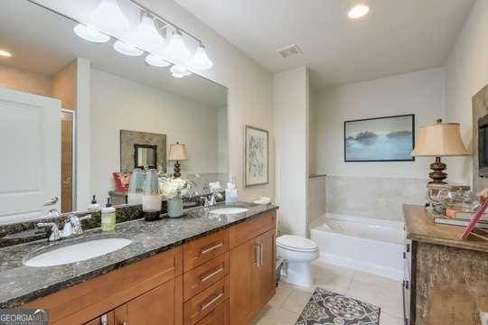 bathroom with tile patterned flooring, vanity, toilet, and a bathing tub