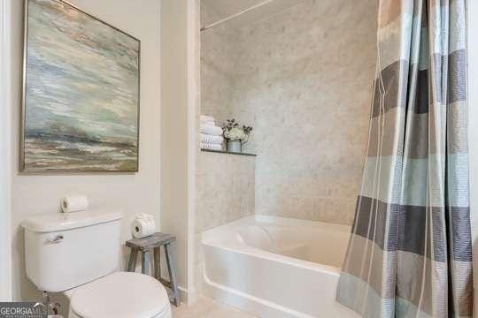 bathroom featuring toilet and shower with separate bathtub