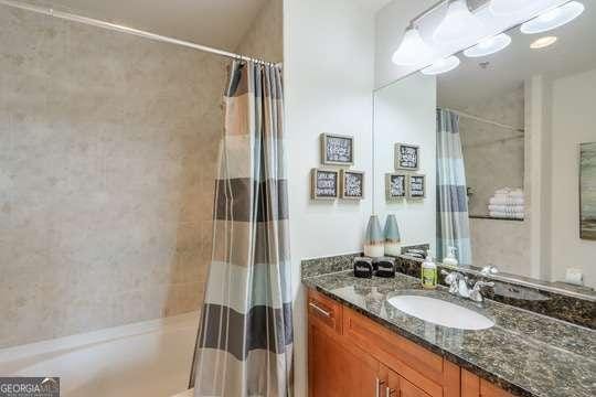 bathroom featuring vanity and shower / bathtub combination with curtain