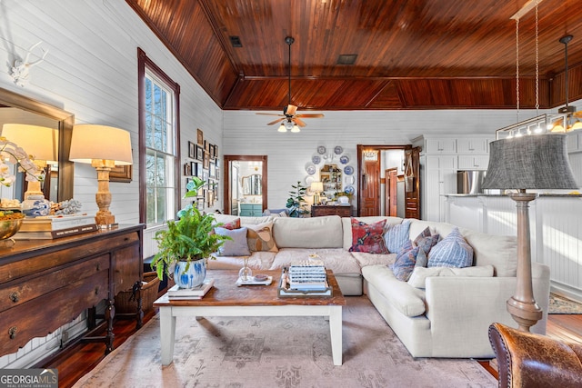 living room featuring ceiling fan, wood walls, and wood ceiling