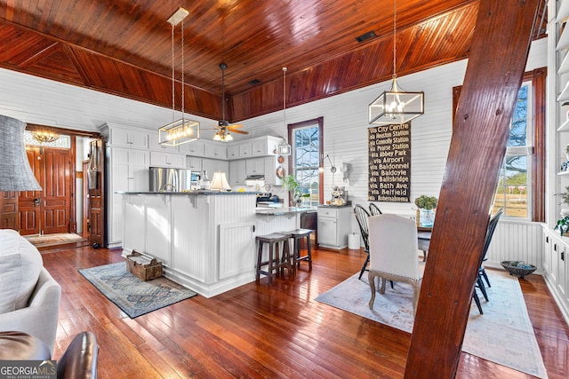 dining space featuring ceiling fan, wood ceiling, and hardwood / wood-style flooring