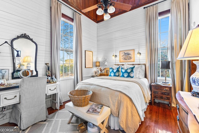 bedroom with ceiling fan, dark hardwood / wood-style flooring, and wooden ceiling