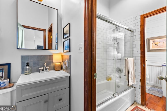 bathroom featuring vanity, shower / bath combination with glass door, and backsplash