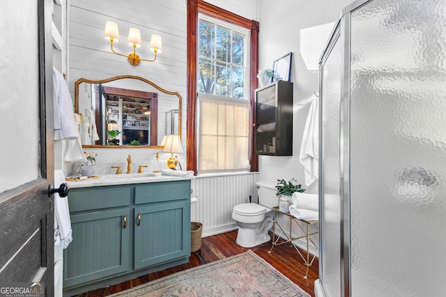 bathroom with vanity, wood-type flooring, walk in shower, and wooden walls