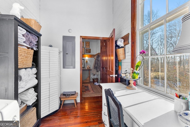 office with a towering ceiling, electric panel, and a healthy amount of sunlight