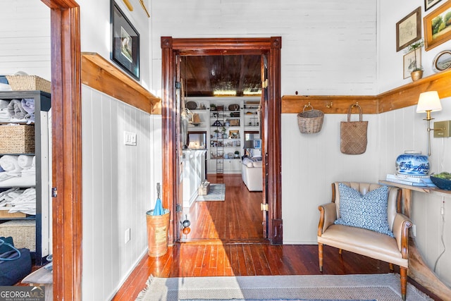 corridor with wood walls and wood-type flooring