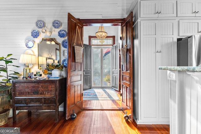 foyer with hardwood / wood-style floors and an inviting chandelier