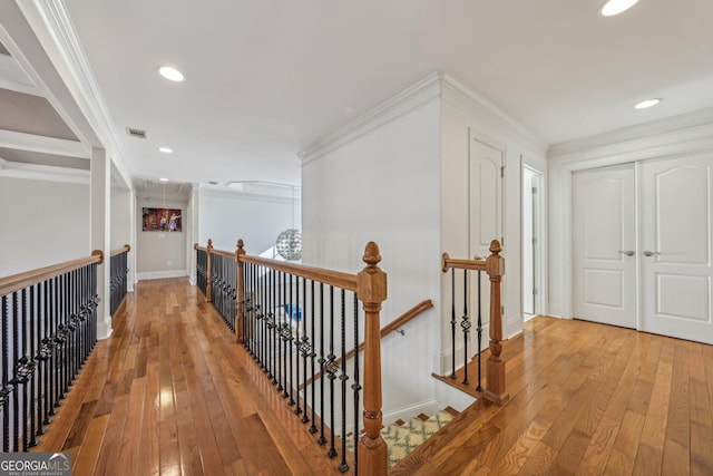 hall with hardwood / wood-style floors and ornamental molding