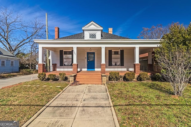 view of front of house with covered porch and a front lawn