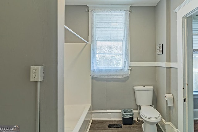 bathroom featuring toilet and a washtub