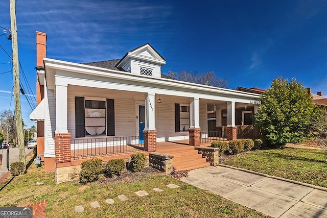 view of front of home with covered porch and a front lawn