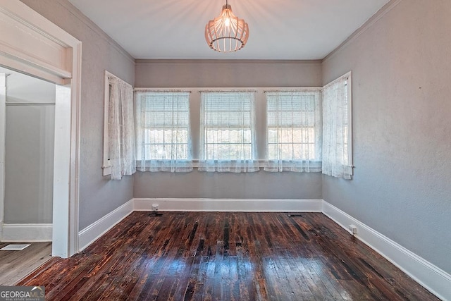 unfurnished dining area featuring ornamental molding and dark hardwood / wood-style floors