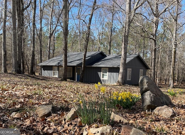 view of side of property with a view of trees and board and batten siding