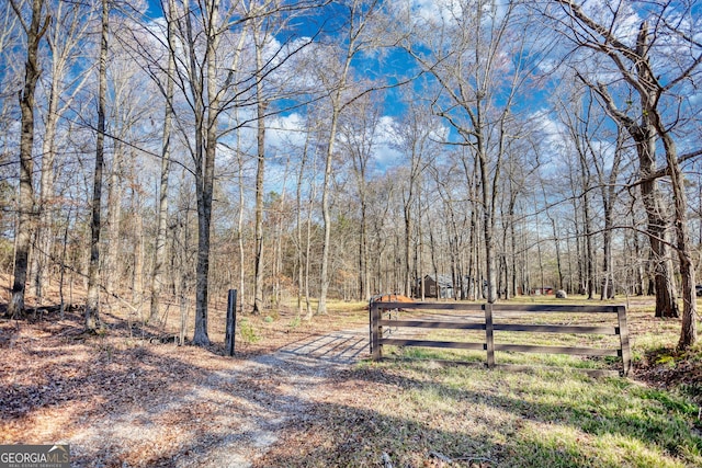 view of yard with fence and a wooded view