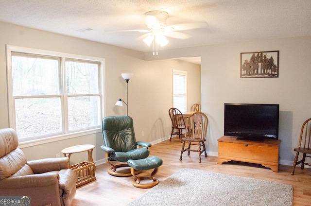 living area featuring wood-type flooring and ceiling fan