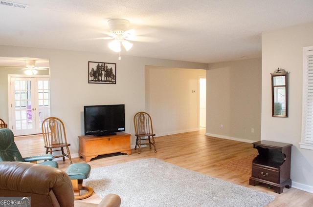 living room featuring ceiling fan and light hardwood / wood-style flooring