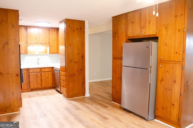 kitchen with stainless steel appliances and light hardwood / wood-style floors