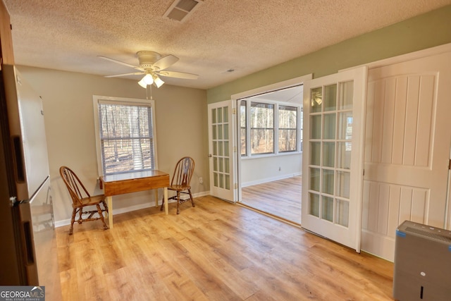 sitting room with light wood-type flooring, visible vents, and plenty of natural light