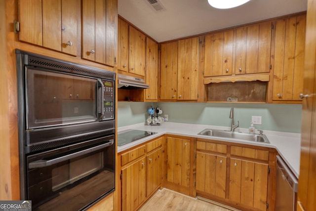 kitchen featuring visible vents, a sink, dishwasher, under cabinet range hood, and black electric cooktop