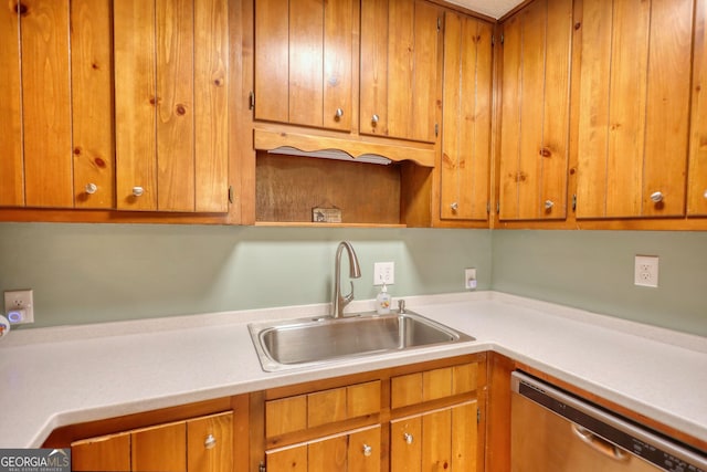 kitchen featuring dishwasher, light countertops, brown cabinetry, and a sink