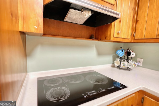 room details with light countertops, under cabinet range hood, and black electric cooktop