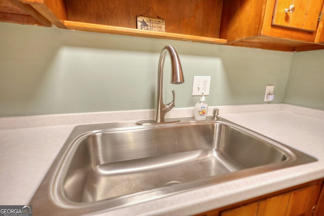 room details with light countertops, brown cabinets, and a sink