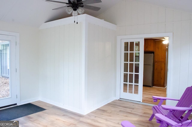 interior space with ceiling fan, vaulted ceiling, light hardwood / wood-style flooring, and french doors