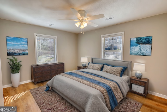 bedroom featuring multiple windows, light wood-type flooring, and visible vents