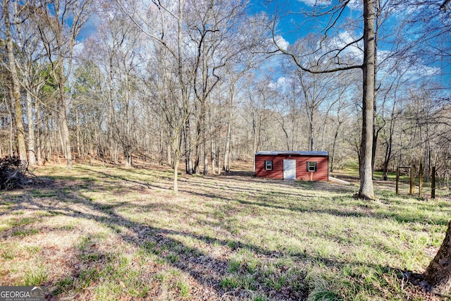 view of yard featuring an outbuilding and a view of trees