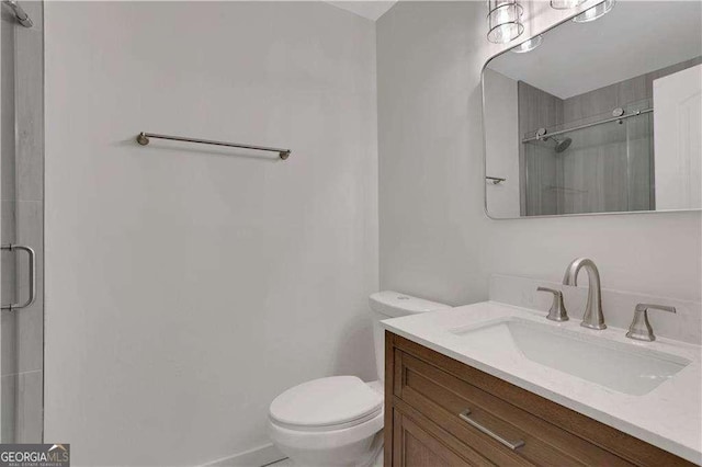 bathroom featuring an enclosed shower, vanity, and toilet