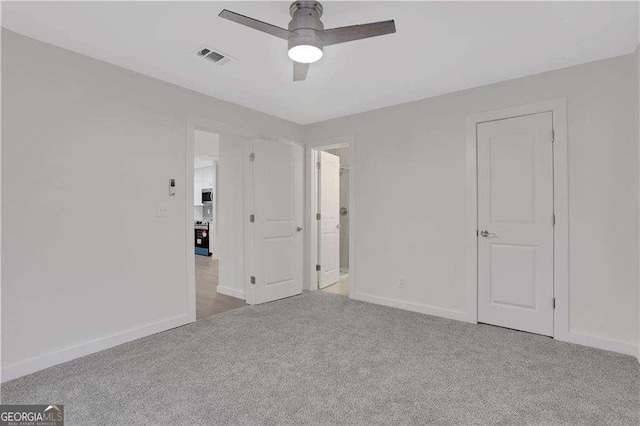 carpeted spare room featuring ceiling fan