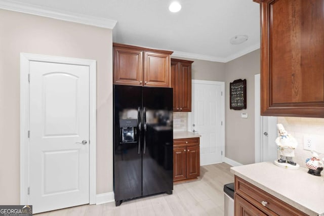 kitchen with decorative backsplash, black refrigerator with ice dispenser, light hardwood / wood-style flooring, and ornamental molding