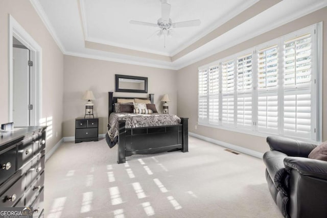 carpeted bedroom featuring a tray ceiling, ceiling fan, and crown molding