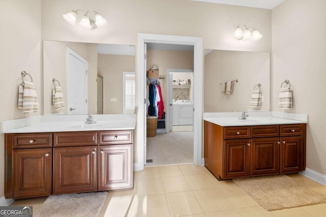 bathroom featuring tile patterned flooring, vanity, and washing machine and dryer