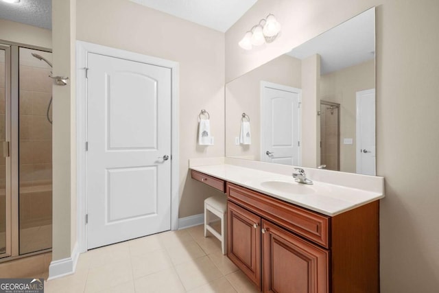 bathroom featuring a shower with door, vanity, a textured ceiling, and tile patterned flooring