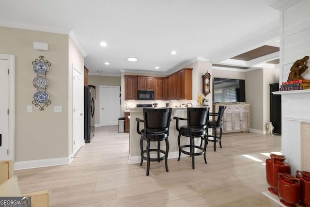 kitchen featuring a kitchen breakfast bar, refrigerator, crown molding, light hardwood / wood-style floors, and kitchen peninsula