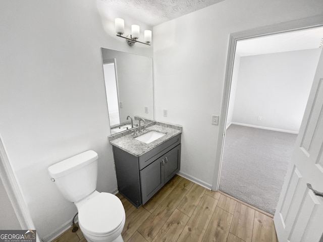 bathroom with vanity, a textured ceiling, and toilet