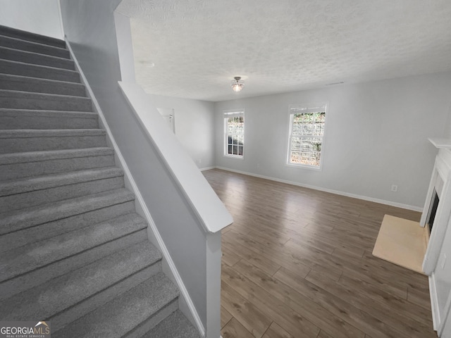 stairway featuring hardwood / wood-style floors and a textured ceiling