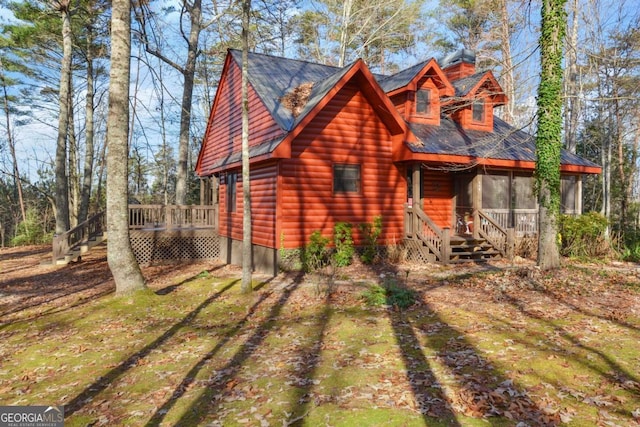 log-style house featuring a wooden deck