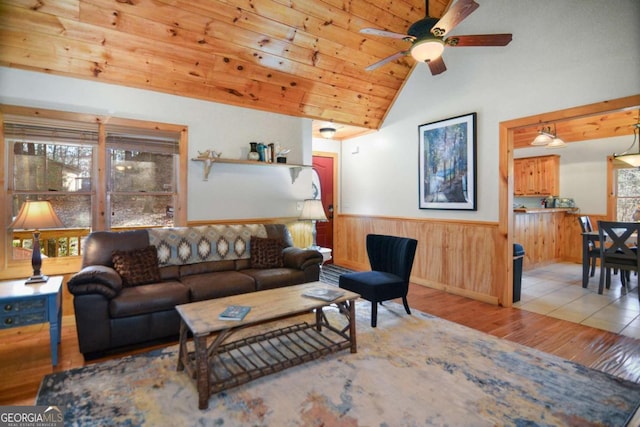 living room with light wood-type flooring, vaulted ceiling, ceiling fan, and wood ceiling