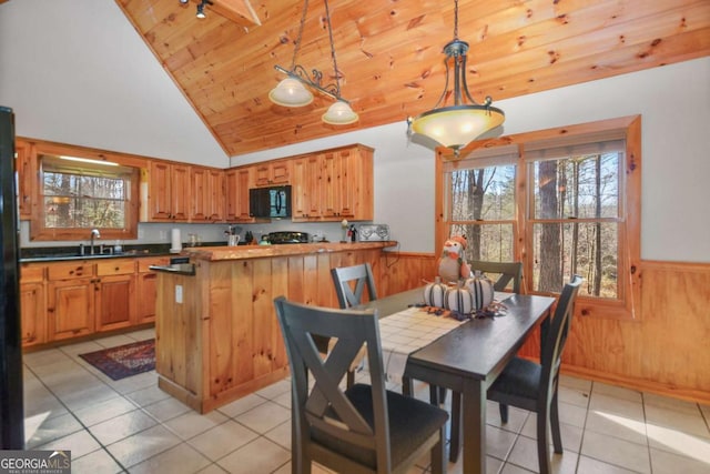 kitchen featuring wooden walls, pendant lighting, wooden ceiling, lofted ceiling, and light tile patterned flooring