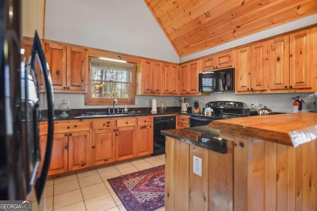 kitchen featuring wood counters, vaulted ceiling, sink, black appliances, and light tile patterned flooring