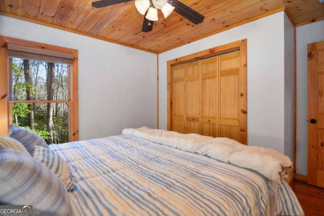 bedroom featuring ceiling fan, wood-type flooring, wood ceiling, and a closet