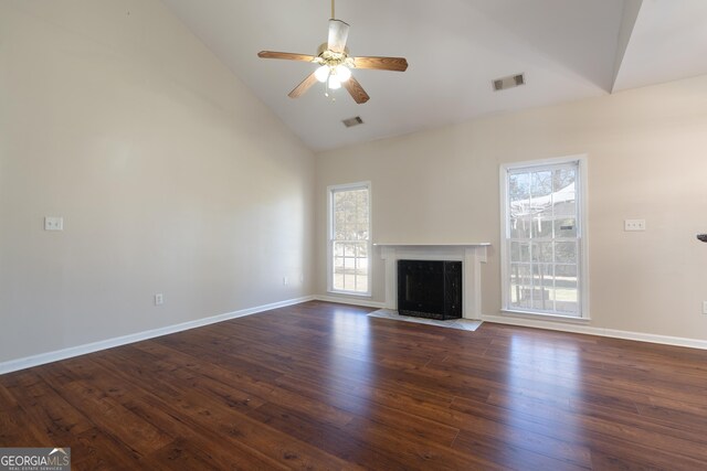 living room featuring dark hardwood / wood-style flooring, a towering ceiling, and ceiling fan