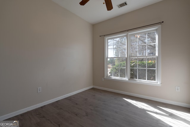 empty room with a ceiling fan, wood finished floors, visible vents, and baseboards