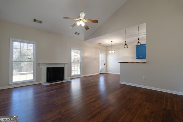 unfurnished living room with dark wood-style floors, a wealth of natural light, and visible vents